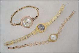 A group of three ladies wrist watches.  One Claridge gold plated cushion Swiss made piece with a