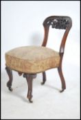 A 19th century walnut nursing chair having a carved open back frame with over stuffed seat pad.