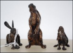 A good group of three detailed modern contemporary cast bronze Hares of graduating size and in