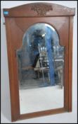 A 1940's oak wall mirror of large form having a central plate bevelled edge mirror. The oak frame
