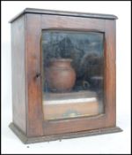 A Victorian oak smokers cabinet with glass door ho
