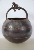 An early burnished iron cauldron of crude construc