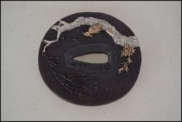 A Japanese bronze Tsuba signed with river and cher