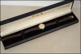 A vintage 9ct gold cocktail dress watch by Roamer having an 18 jewel movement and a black leather