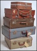 A stack of vintage mid century suitcases to include coloured vinyl examples, chequered vanity cases,
