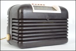 A vintage mid 20th century Bakelite Bush radio TYPE DC10 having dials and speaker to the front and