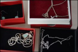 A small collection of three boxed silver jewellery necklaces each with pendants together with a pair