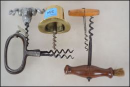 A collection of corkscrews to include a white metal rams head screw  a brass top hat, mahogany