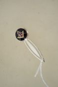 A silver and enamel bookmark with masonic symbol.