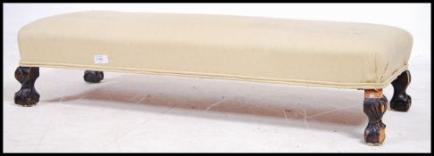 A 19th century Victorian long footstool being rais