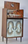 A mid century retro cocktail cabinet having coloured art glass sliding doors with articulated top