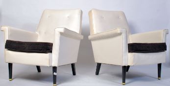 A  retro 1960's pair of Greaves & Thomas ' Longline ' vinyl armchairs. Raised on tapering ebonised
