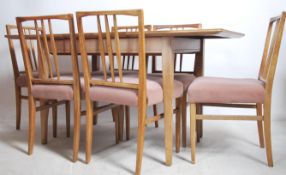 An original Gordon Russell walnut extending dining room table together with a set o 6 dining