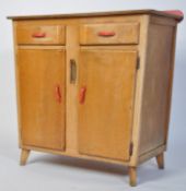 A vintage mid 20th century kitchen sideboard in beech wood with oak veneers having a red formica top