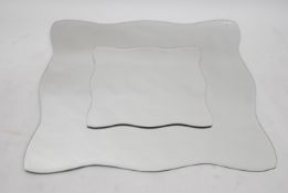 A large late 20th century ' picture in picture ' mirror of square form with flowing bevelled edges ,