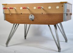 A 1970's retro  large table football foosball game. Raised on large cast metal hairpin legs with
