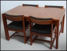 A 1960's teak wood Danish influence dining table and 4 chairs - suite. The table of chunk teak