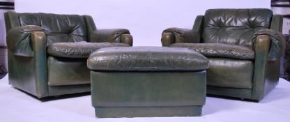 A pair of mid century leather armchairs in the manner of Minty complete with ottoman footstool.