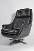 A vintage retro 20th century Danish vinyl upholstered recliner swivel easy chair raised on chromed