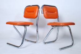 A pair of 1970's retro chrome tubular orange vinyl upholstered dining chairs. Raised on stunning