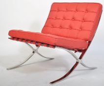 A contemporary Barcelona chair after the original by Mies van der Rohe being upholstered in red