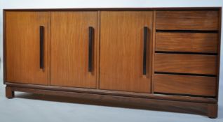 A 1960's Danish teak sideboard dresser of large proportions being raised on a teak suspension set