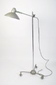 A floorstanding full size Sollux Industrial lamp raised on a spider leg base with ball wheel castors