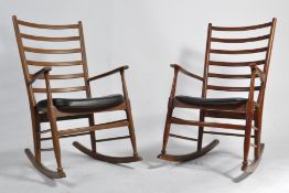 A rare pair of 1960's Danish teak wood rocking chairs being raised on turned supports with sleigh