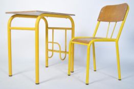 A retro 20th century childs school desk and chair having tubular metal yellow frames, each with