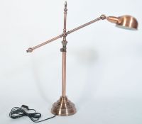 A fabulous polished copper anglepoise desk lamp raised on terraced base with tubular construction