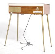 A 1950's Marinucci laquered organ being raised on tapering supports with laquered wooden body with