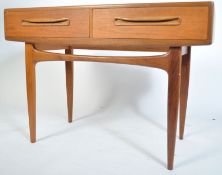 A 1970's G-plan Kofod Larsen teak wood writing table desk being raised on tapered supports with