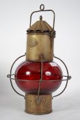 An early 20th century nautical brass ships onion shaped lantern. Having red glass onion shade,