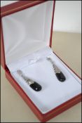 A pair of silver onyx and marcasite Art Deco style