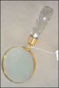 A hand held magnifying glass with a faceted glass