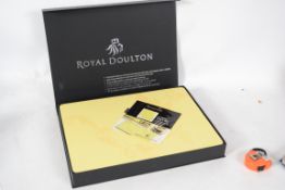 A boxed Royal Doulton place matts and coaters set in the ' Sensuality ' pattern.