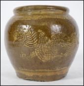 An early oriental brown stoneware jar depicting dr