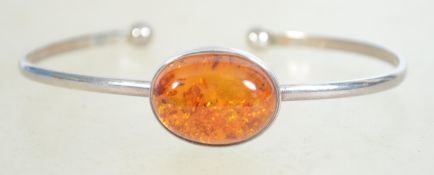 A sterling silver and amber bangle bracelet having