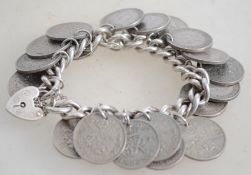 A sterling silver coin bracelet chain having a hea
