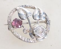 A vintage silver shield brooch with central flower