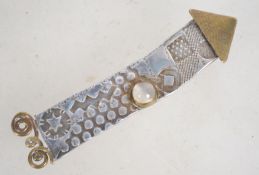 A vintage silver brass and moonstone rocket brooch