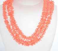 A vintage 1950s faux coral plastic three strand ne