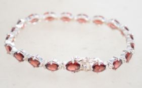 A sterling silver and garnet bracelet having facet
