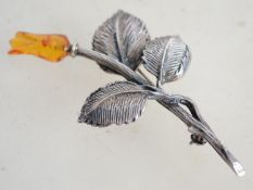 A sterling silver and amber brooch in the form of