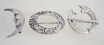 A group of three sterling silver brooches one of C