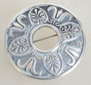 A sterling silver circular shield brooch having a