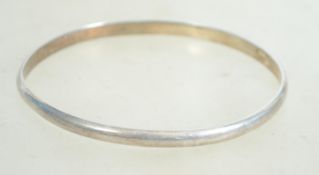 A sterling silver bangle bracelet of circular form