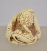 A Chinese carved bone netsuke signed to the base.