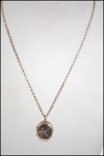 A 9ct gold chain strung with a rolled gold locket