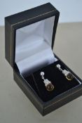 A pair of white gold and yellow stone earrings. Me